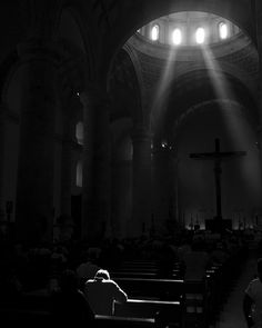 the sun shines brightly through the windows in a church as people sit on pews