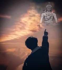 a man pointing at a statue in the sky