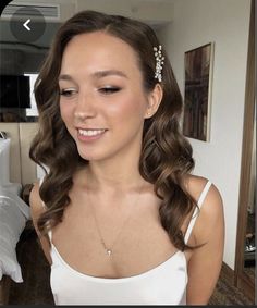 a woman with long hair wearing a white top