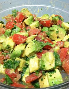 a salad with cucumbers, tomatoes and onions in a white bowl on a table