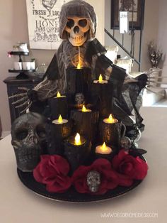 a skeleton sitting on top of a table with candles