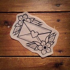 a sticker that is on the side of a wooden table with flowers and an envelope