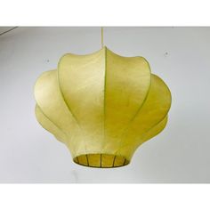 a yellow paper lantern hanging from a ceiling in the shape of a flower or leaf