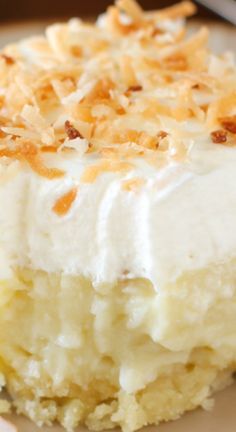 a piece of cake with white frosting and toasted coconut toppings on top