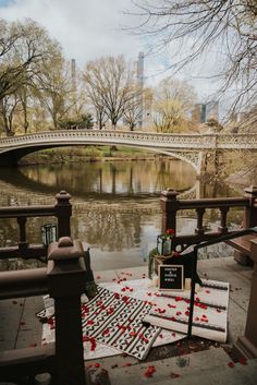 a bridge over a river with rose petals on the ground