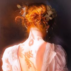 the back of a woman's body with flowers in her hair and dress on