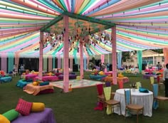 an outdoor event with tables and chairs covered in colorful cloths