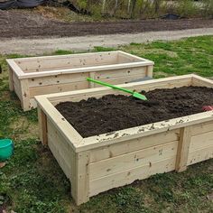 two wooden raised garden beds with dirt in them