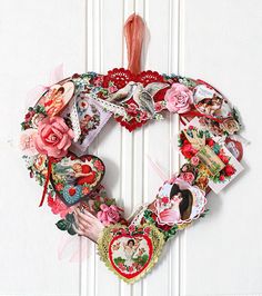 a heart shaped wreath is hanging on the wall with pictures and hearts attached to it