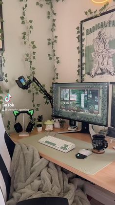 there is a computer on the desk in front of a wall with ivy growing up it