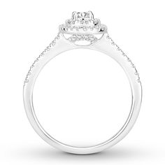 a white gold engagement ring with diamonds on the shoulders and an oval shaped center stone