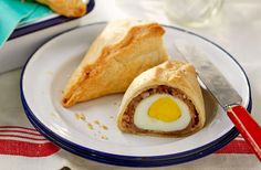 an egg roll is on a plate with a knife and fork next to the pastry