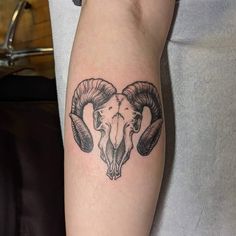 a ram skull tattoo on the left arm