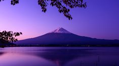 a mountain is in the distance with water and trees around it