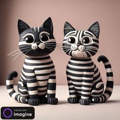 two black and white cat figurines sitting next to each other on a table