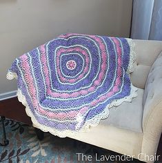 a crocheted blanket sitting on top of a white chair next to a window