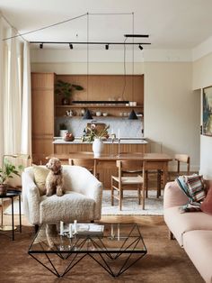 a living room filled with furniture and a dog sitting on top of a chair in front of a table