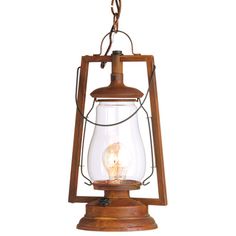 an old fashioned light hanging from a wooden frame with a glass bulb in the center