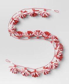 the letter e is made up of red and white beads with tassels on each end