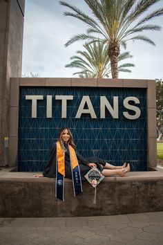 a woman sitting in front of a sign that says titans