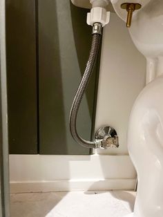 a white toilet sitting in a bathroom next to a shower head and hand held faucet