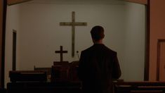 a man standing in front of a cross