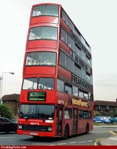 a red double decker bus driving down the street