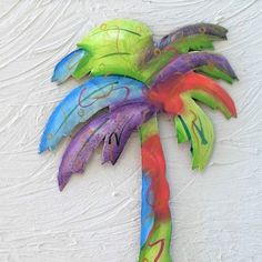 a colorful palm tree made out of paper mache on a white background with the letter n