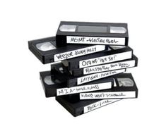 five black and white cassettes stacked on top of each other with writing on them