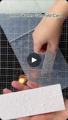 someone is cutting out a snowflake pattern on a piece of clear plastic with a knife