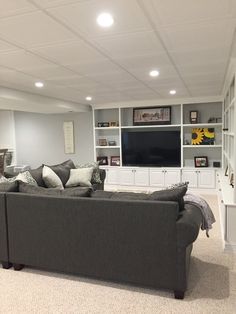 a living room filled with furniture and a flat screen tv mounted on a wall above it