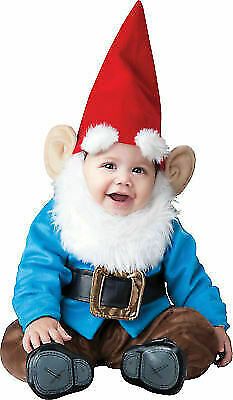 a baby dressed in a blue and red gnome costume sitting on the ground with his legs crossed