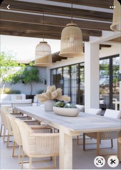 an outdoor dining area with chairs, table and potted plants