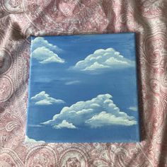 a painting of clouds on a blue background