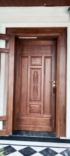 a wooden door is shown in front of a white wall and black and white checkered floor