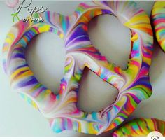 three multicolored doughnuts are arranged in the shape of a peace sign