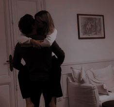 two people are hugging in the living room