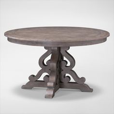 a round wooden table with an intricate design on the top and base, sitting against a white background