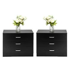 two vases with flowers are sitting on top of the drawers in front of each other