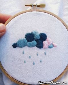 someone is stitching something together in the shape of two birds on a rainy day