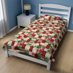 a bed with a red and green plaid comforter on it