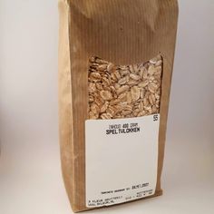 a brown paper bag filled with nuts on top of a white table