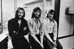 the bee gees posing for a photo in an office