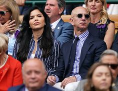 two people sitting next to each other at a tennis match in front of an audience