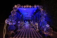 an entrance decorated with blue lights and balls on the floor in front of a black and white checkered floor