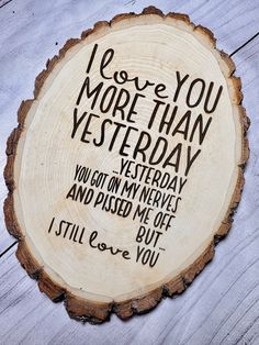 i love you more than yesterday sign on a wood slice with words written in black ink