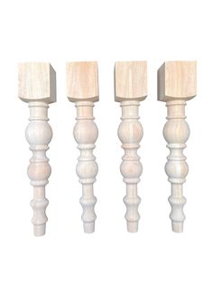 three white wooden posts with wood tops on a white background, one is turned upside down and the other two are straight