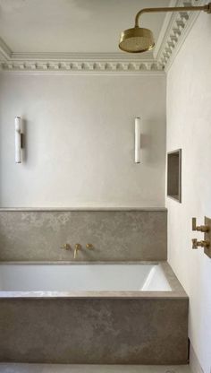 a bathroom with a bathtub and two faucets on the wall next to it