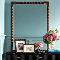 a dresser with flowers and pictures on it