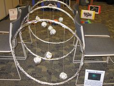 an arrangement of metal objects sitting on top of a carpeted floor next to chairs